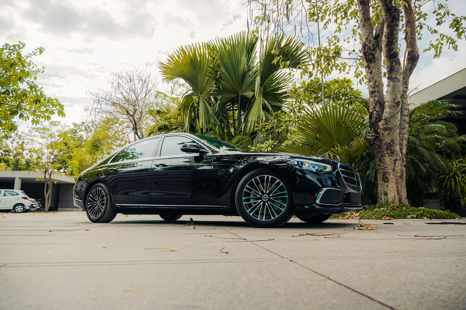 Black luxury sedan waiting on a palm-lined Beverly Hills boulevard