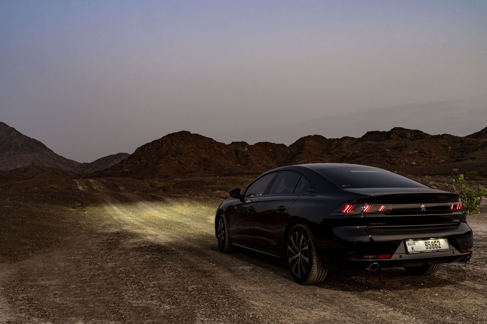 Luxury sedan on a desert highway near Las Vegas at sunset