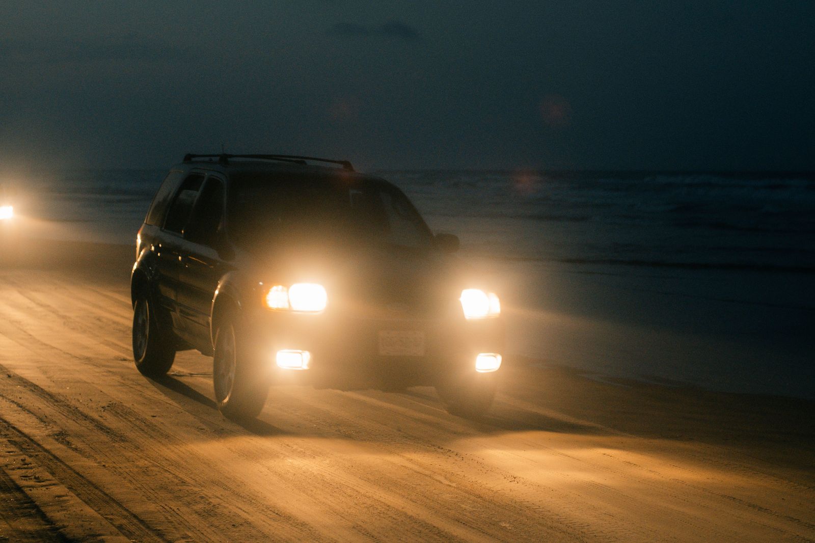 Black SUV on Ocean Drive in Miami Beach at dusk