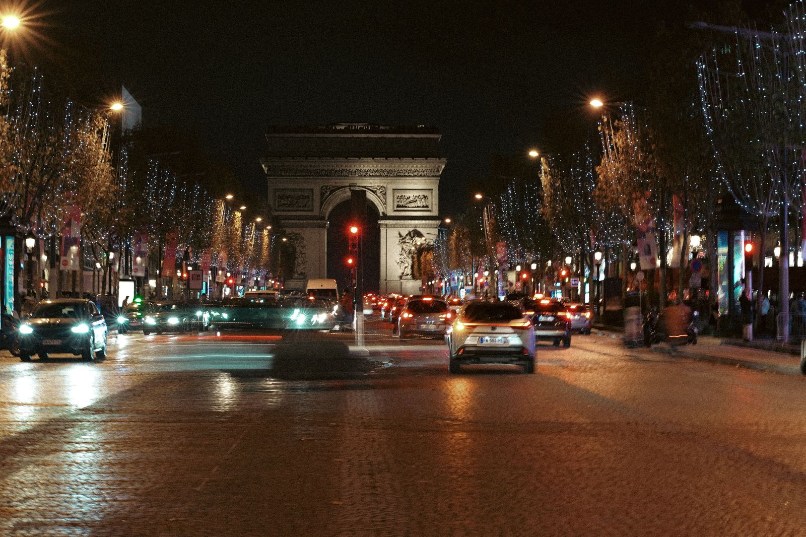 Black sedan on a Paris boulevard at night
