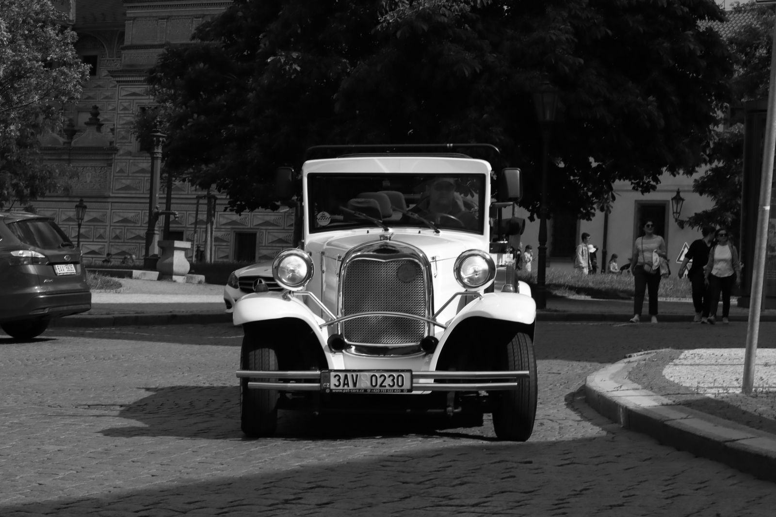 Black car on a cobbled Prague street in the evening