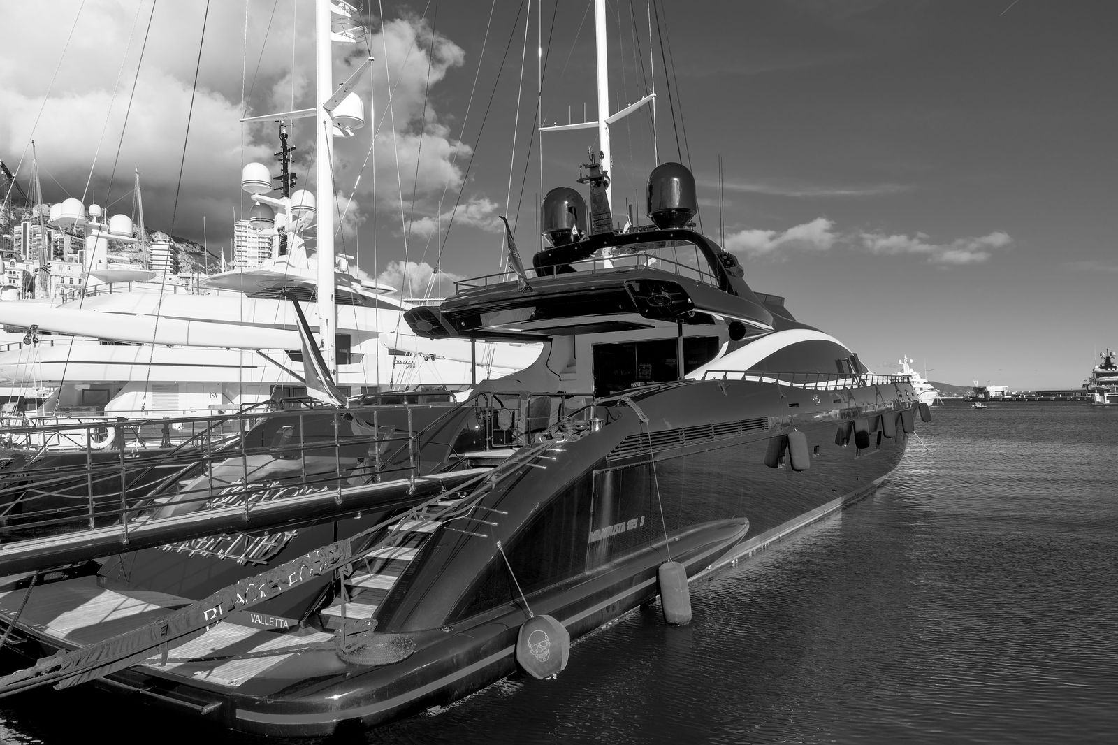 Superyacht moored stern-to on a Mediterranean quay in the evening