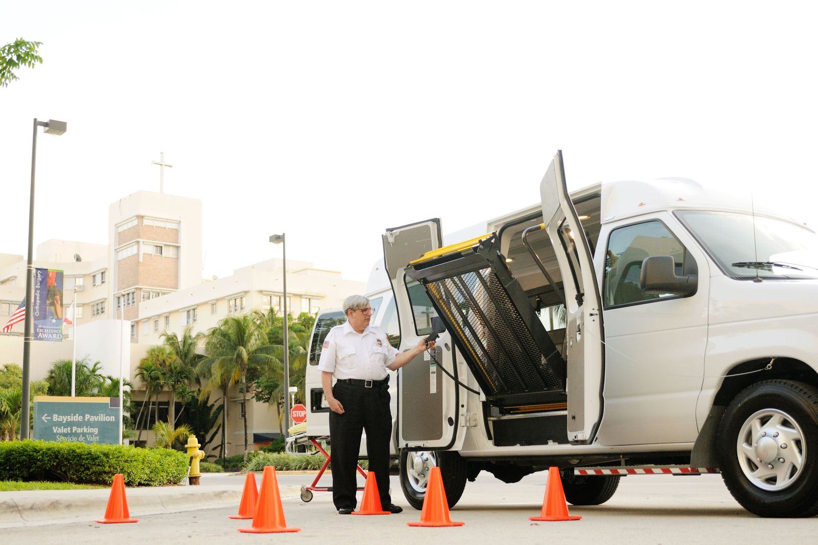 Shuttle vans waiting at a conference centre entrance for delegates